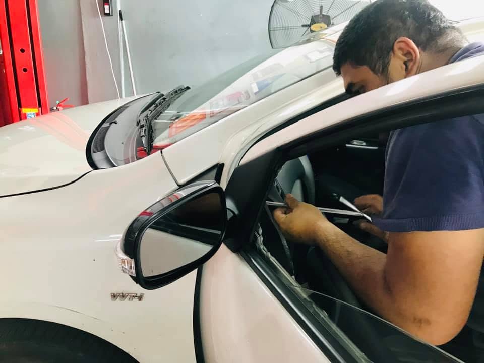 Technician servicing a light vehicle in an MRO workshop